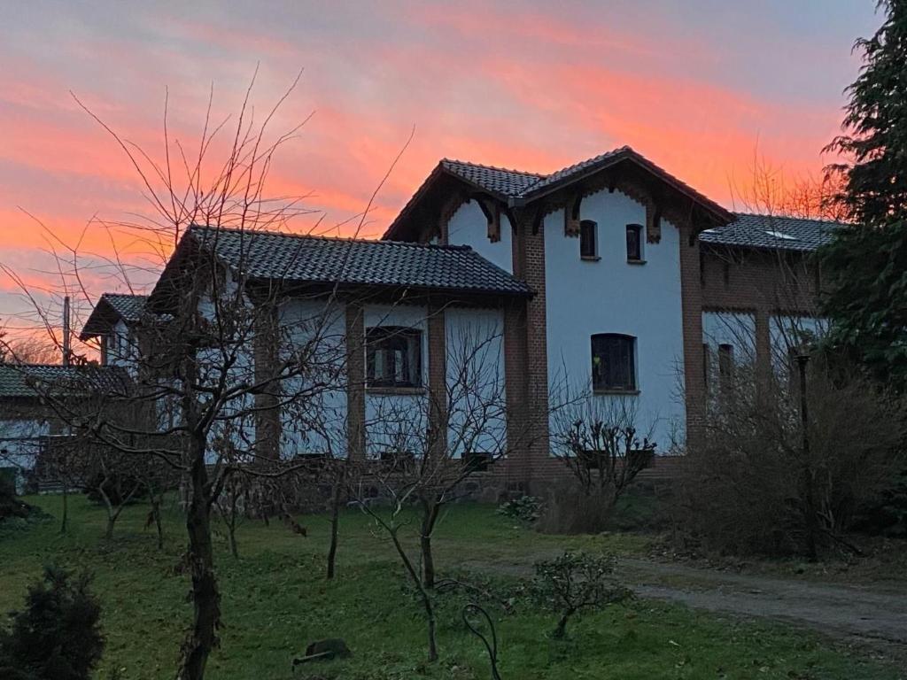 an old house with a sunset in the background at Apartment Turmwohnung by Interhome in Kuchelmiß