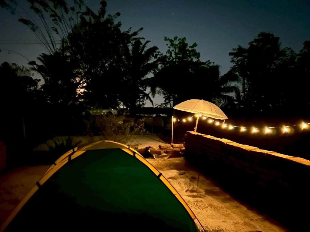 a tent and an umbrella at night with lights at Jantawan Hostel in Ban Khlong Chet (2)