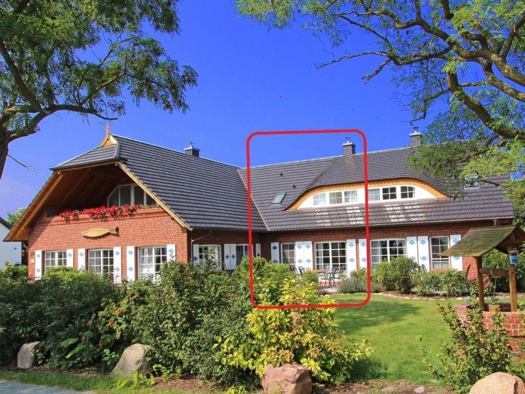 a house with a roof that has a red pole at Apartment Tohus - Wigbold by Interhome in Middelhagen