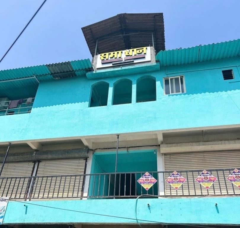a blue building with a sign on top of it at Samadhan lodge in Vangani