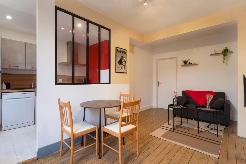 a kitchen and living room with a table and chairs at Hôtel des Cousines Capucine Apartment in Nancy