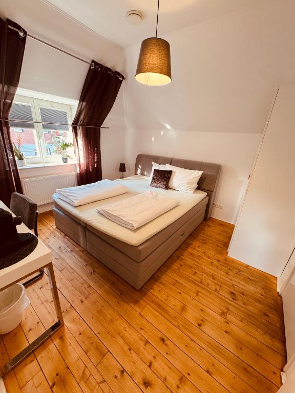 a bedroom with a bed and a wooden floor at Restaurant Hotel Laternchen in Cologne