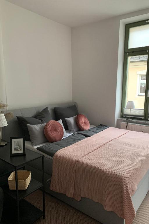 a bedroom with a bed and a couch with pillows at Apartment Stadtwohnung by Interhome in Plauen