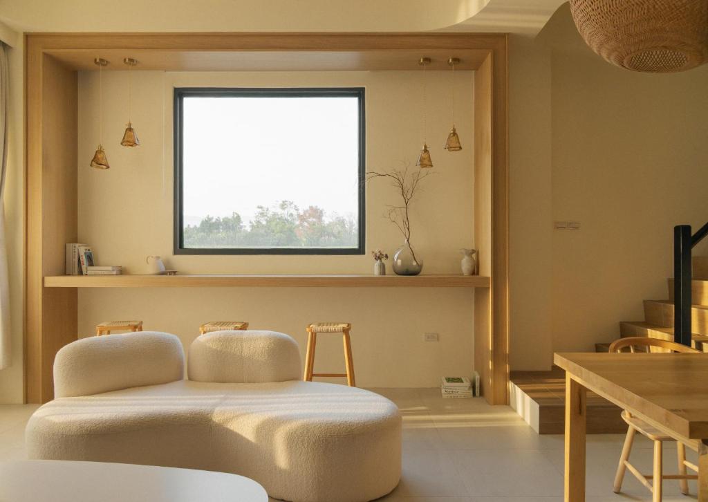 a living room with a stool in front of a window at 倆穗 LightSui Guesthouse in Sanxing