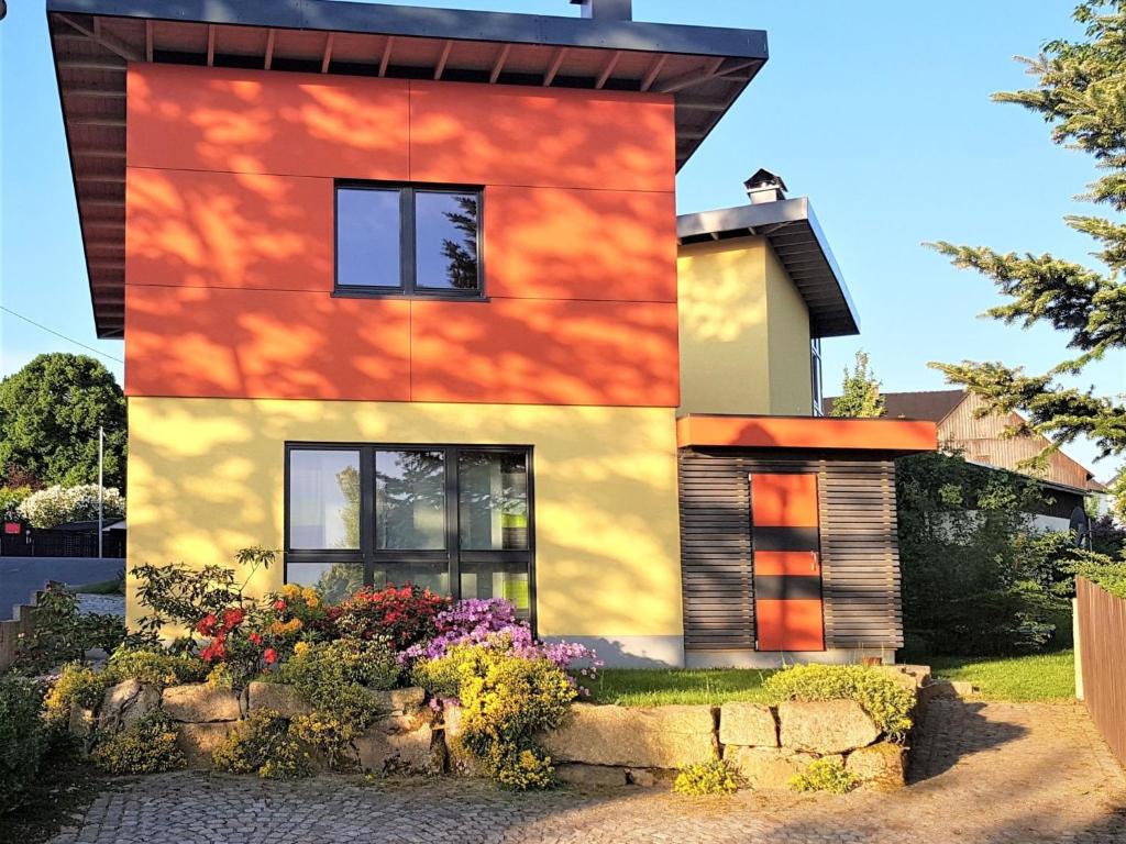 a house that is painted yellow and orange at Holiday Home mit Wallbox by Interhome in Eibenstock