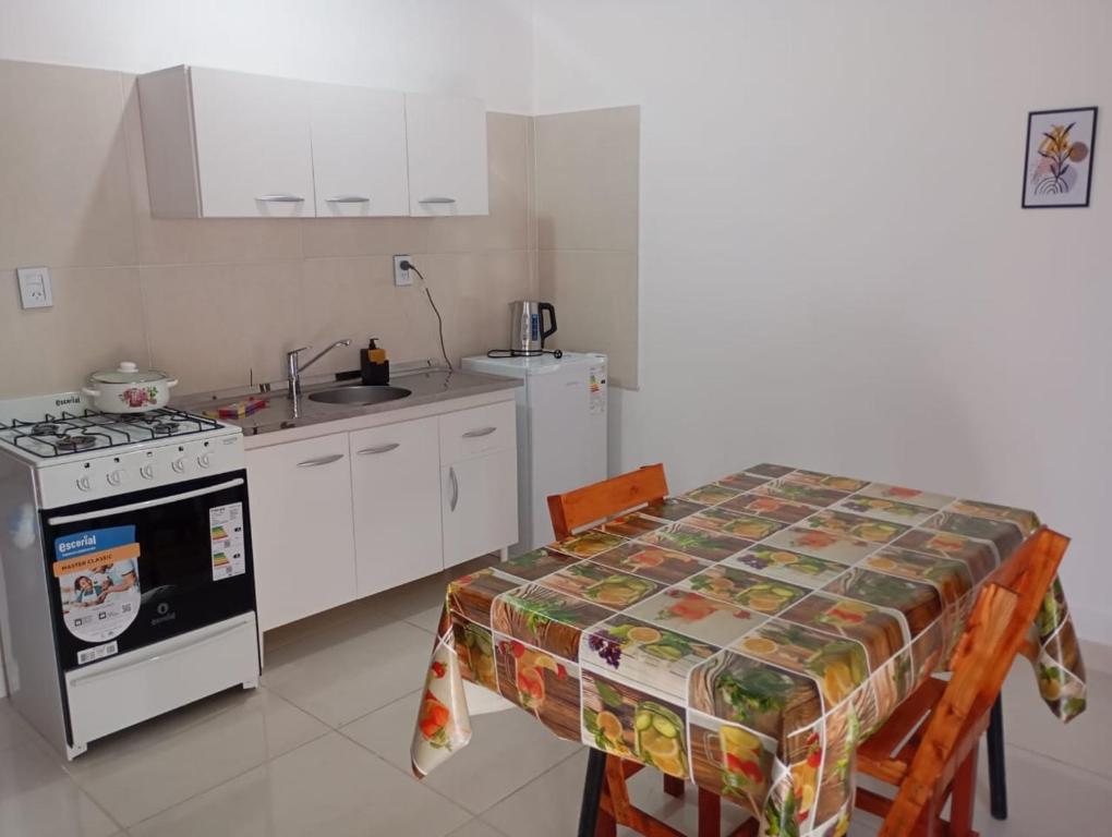 a small kitchen with a table and a stove at Dpto Los Pinos in Fernández