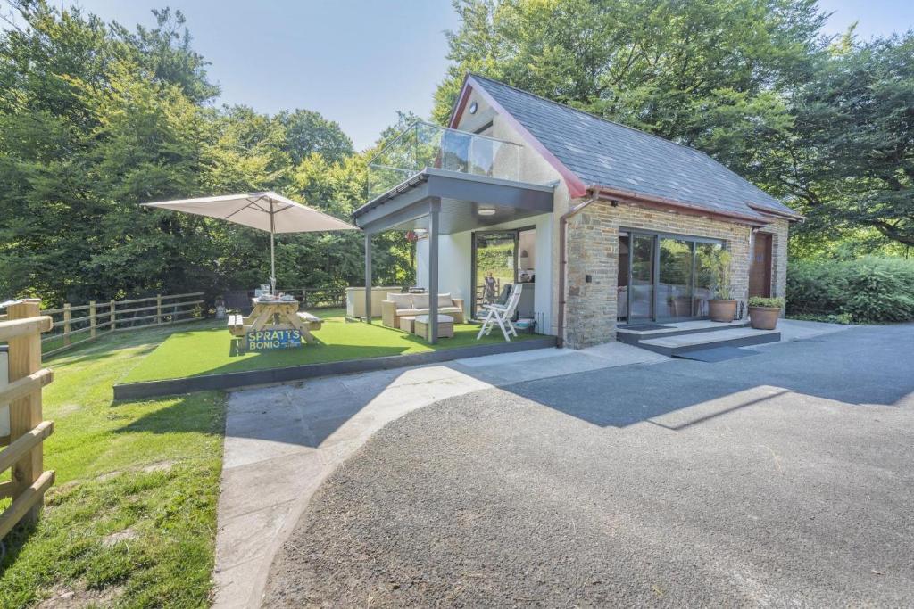 ein kleines Haus mit Terrasse und Sonnenschirm in der Unterkunft 2 Bed in Llanybydder oc-b32255 in Cwrt-newydd