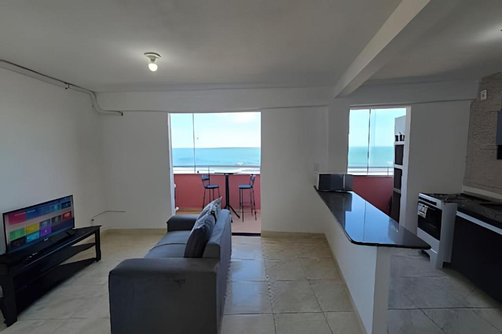 a living room with a couch and a tv at Apartamento Cantinho do Mar in Natal
