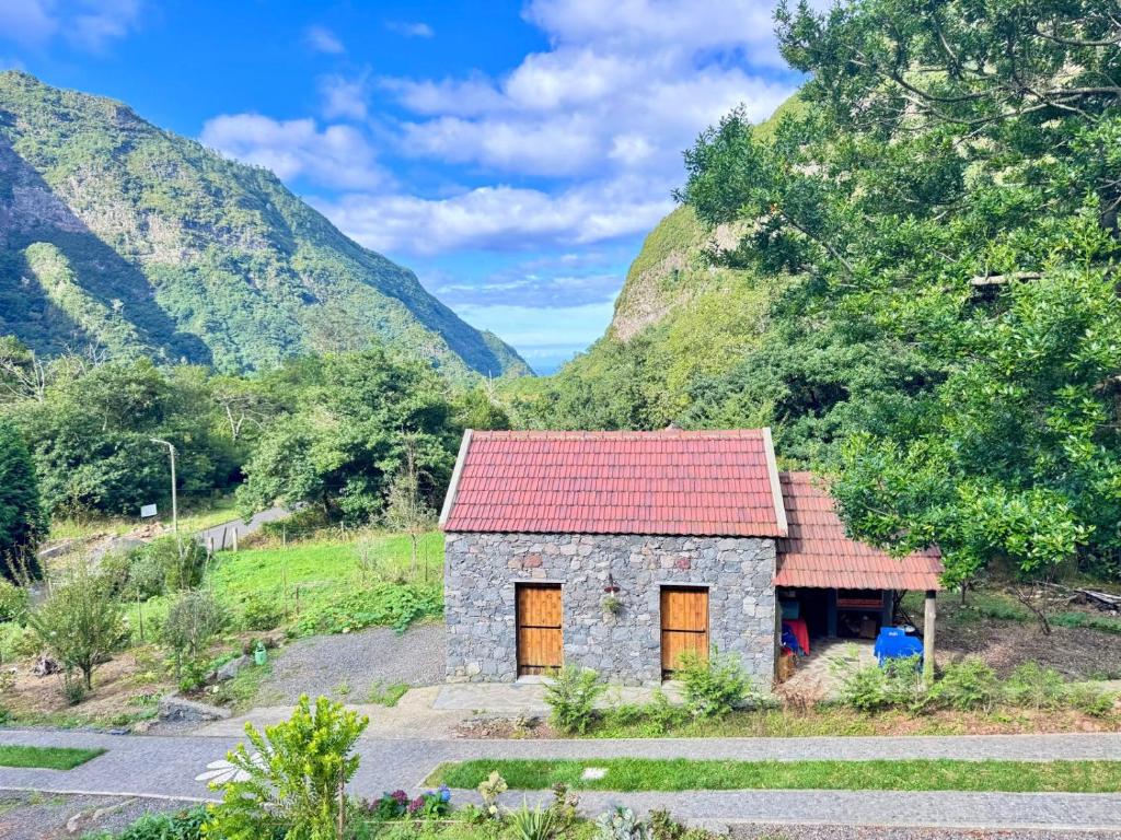 a small stone house with a red roof at Casa do Til in Porto Moniz