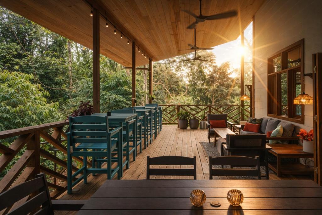 a deck with chairs and tables and the sun shining at La Casa Selva in Bocas Town