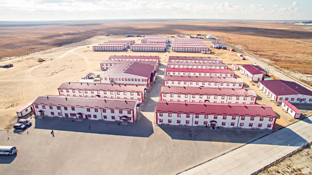 an aerial view of a large building with red roofs at New Tengiz Camp in Tengiz