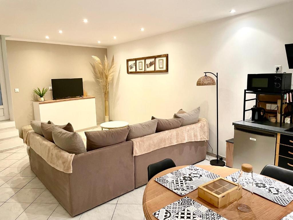 a living room with a couch and a table at Appartement cosy et confortable Chez Lyne in Laragne
