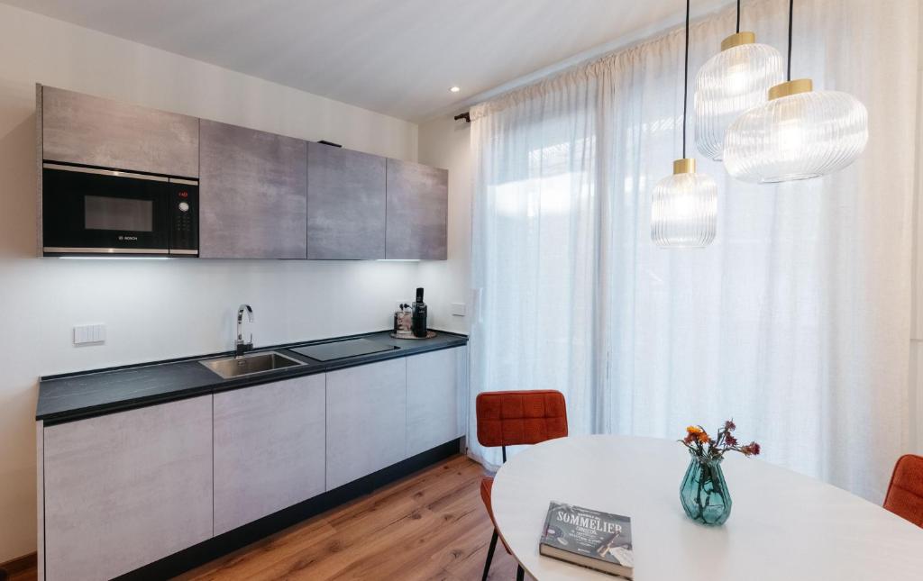 a kitchen with a white table and a white counter top at ecHo Apartments & SPA in Bressanone