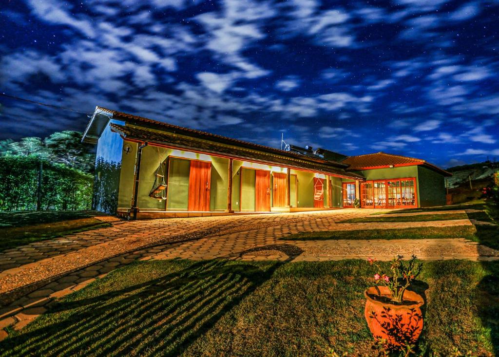 a house with a potted plant in front of it at Pousada Charme da Mantiqueira in Passa Quatro