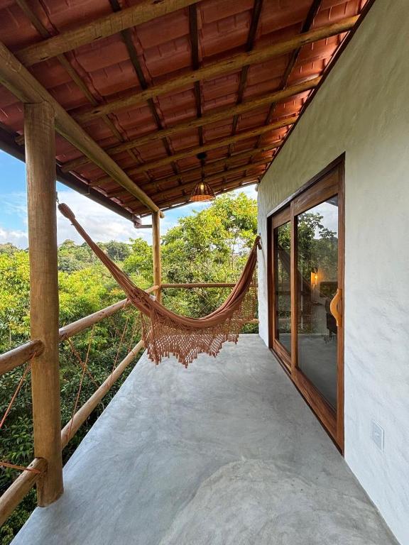 a hammock on the balcony of a house at CASA NANDOS Flat Essência !!! in Itacaré