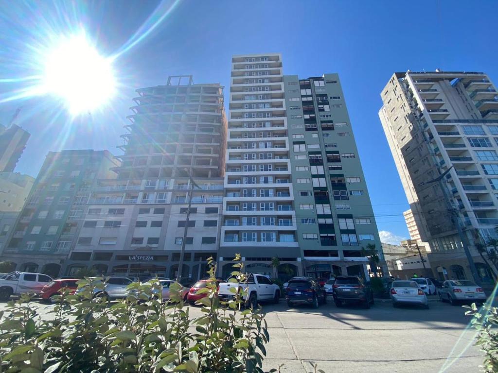 a tall building with the sun in front of it at Oceano in Necochea