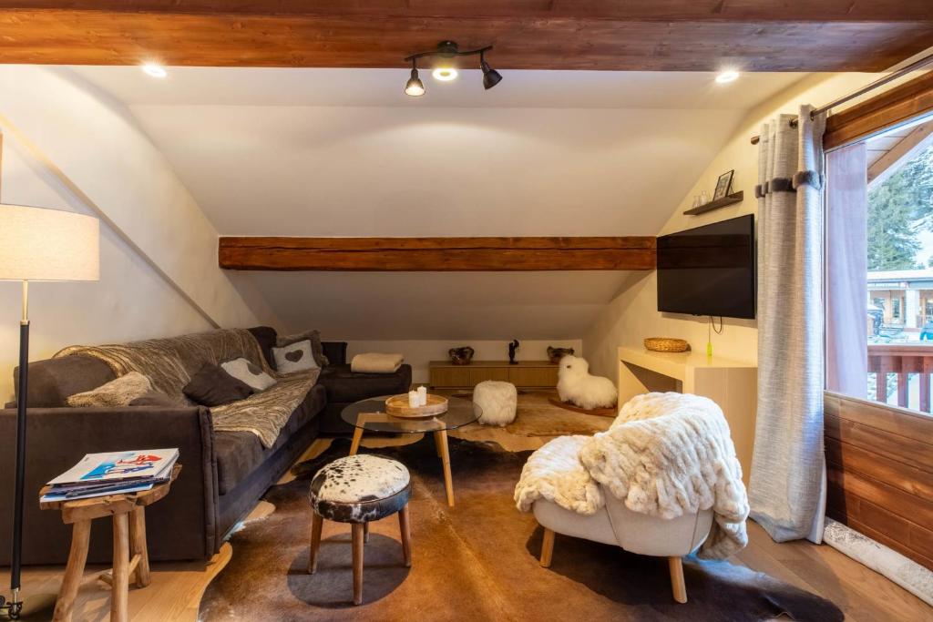 a living room with a couch and a tv at Les Lauzes 32-46 in Mussillon
