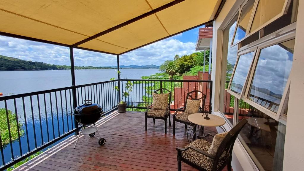 a screened in porch with a view of the water at Harties Boathouse in Hartbeespoort