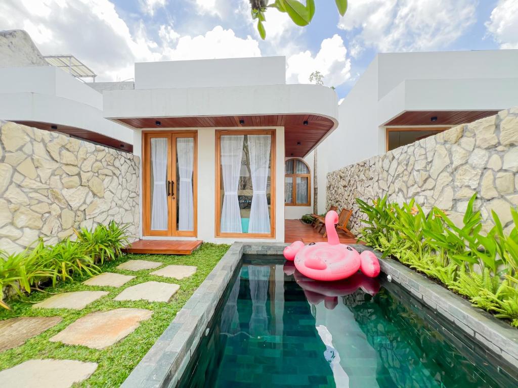a house with a swimming pool with a pink duck in the yard at Among Villa in Yogyakarta