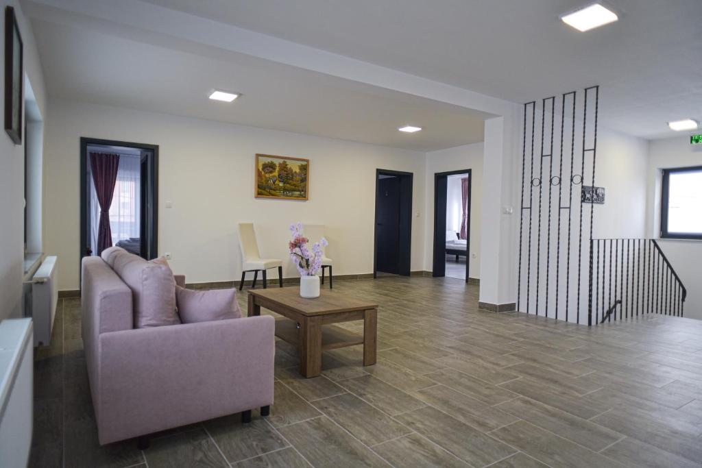 a living room with a couch and a table at Süni Vendégház in Căpîlniţa