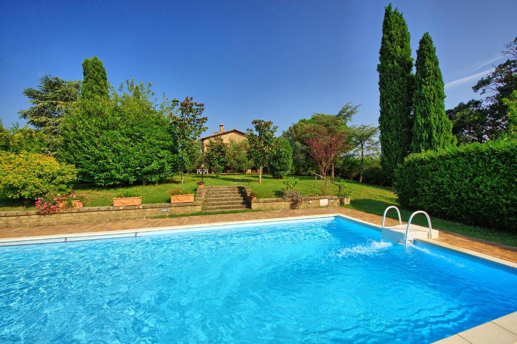 - une piscine dans une cour avec des arbres et une maison dans l'établissement Holiday Home Casale Giulio by PosarelliVillas, à Cetona