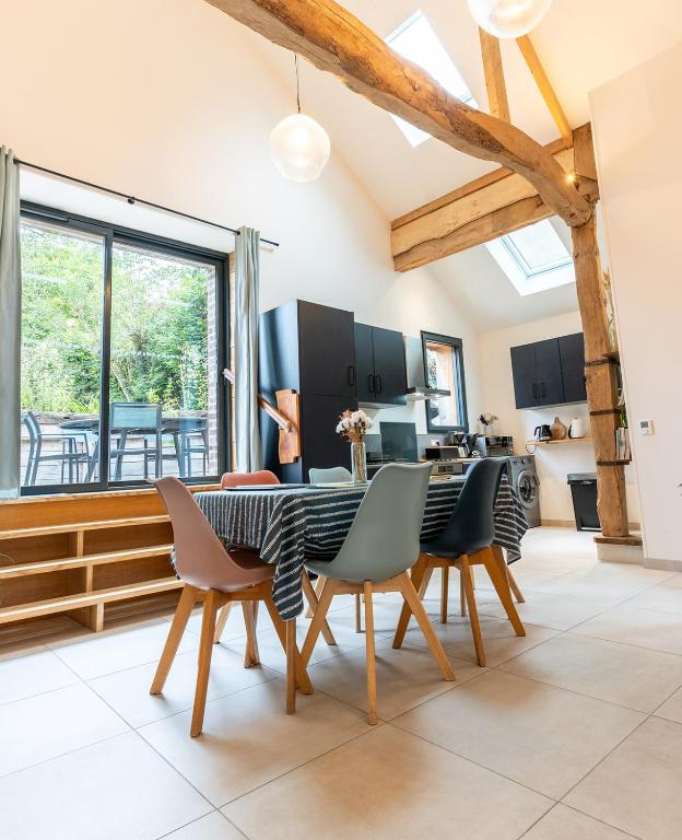 a kitchen and dining room with a table and chairs at Les Bobos à la ferme in La Madelaine-sous-Montreuil