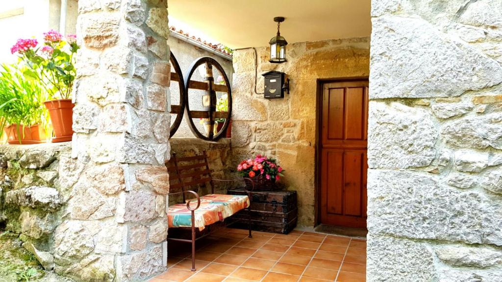 Habitación con pared de piedra y puerta de madera. en La Casina de Toñita, en Cazo