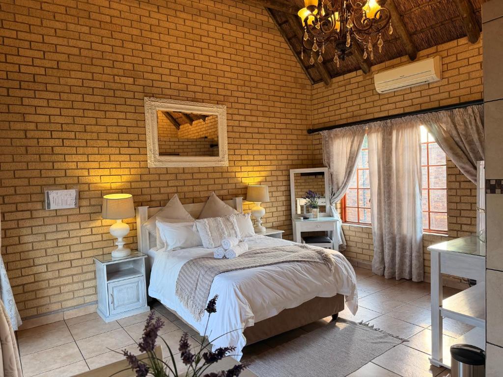 a bedroom with a bed and a brick wall at Accommodation At Thabong in Brakpan