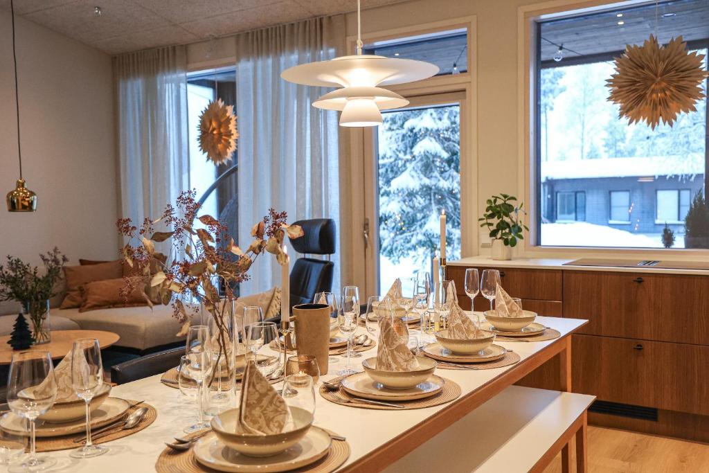 a dining room with a long table with glasses on it at Villa Memory-Aurora view bath-Sauna-Lapland-Santa in Rovaniemi