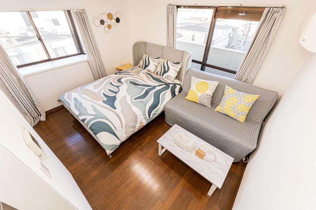 ein kleines Schlafzimmer mit einem Bett und einem Stuhl in der Unterkunft sakura 501 in Tokio