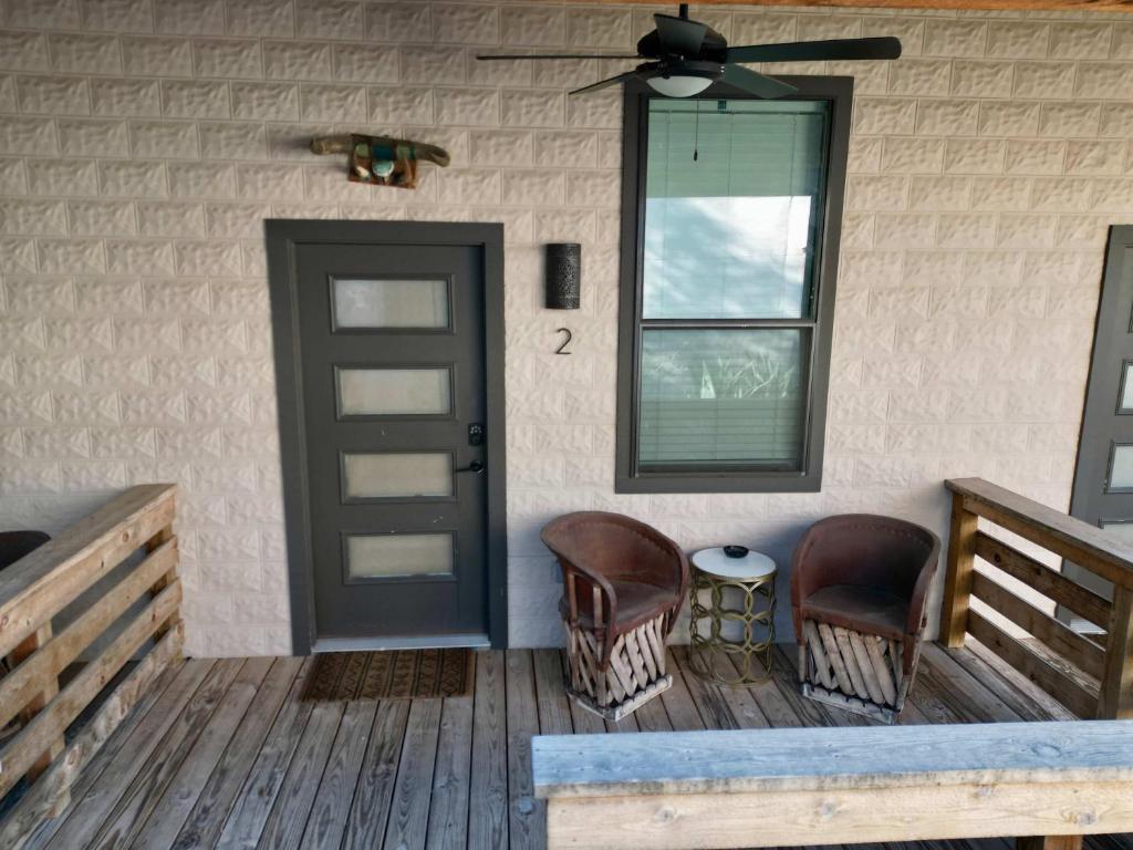 a porch with chairs and a door and a window at Lodge 2 on the Mason TX square in Mason