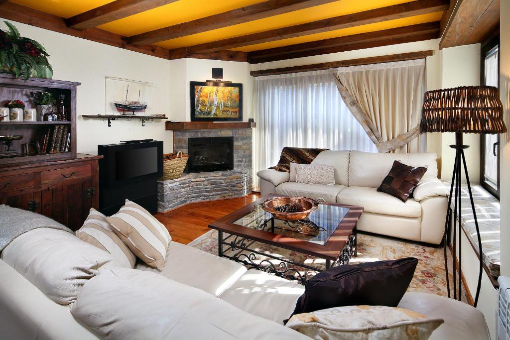 sala de estar con sofás blancos y chimenea en Apartamento Amets de Aran, en Vielha