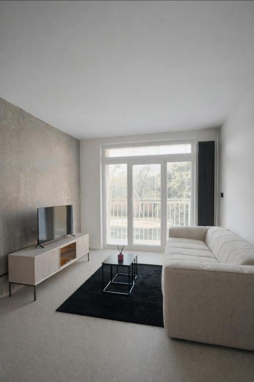 a living room with a couch and a television at Košice Kysucka Apartment in Košice
