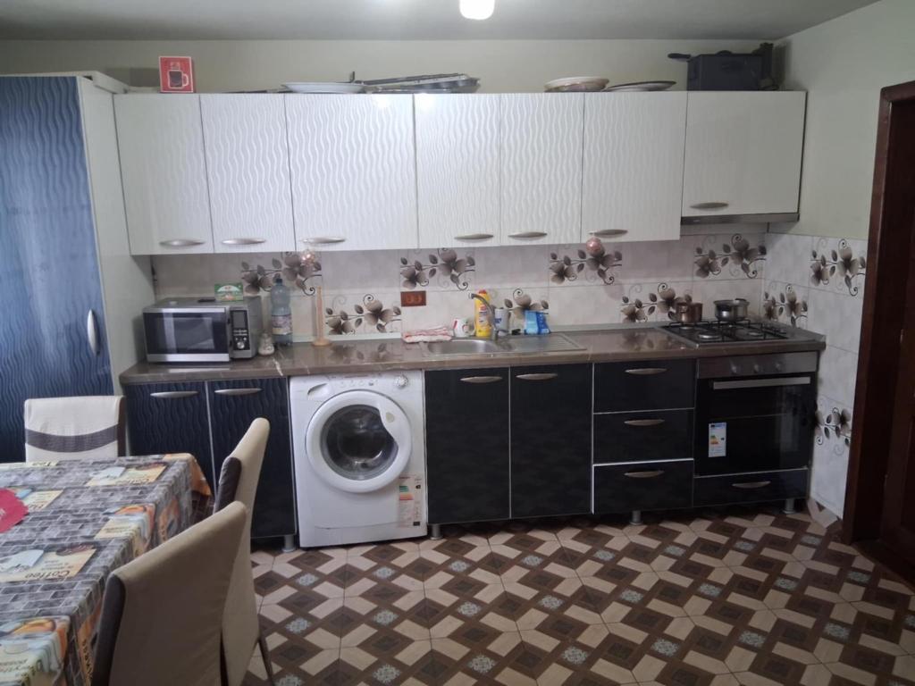 a kitchen with a washing machine and a washer at Colț de Rai in Pirotehnia