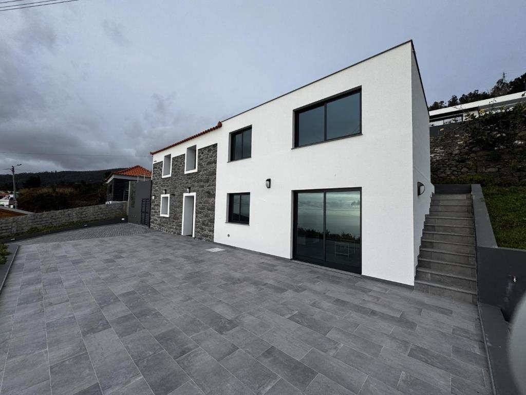 a white house with a large driveway at Hiking & Ocean in Arco da Calheta