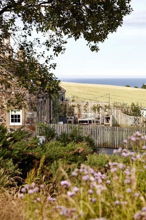 a garden with a fence and a view of the ocean at Banchory Farm in Fife