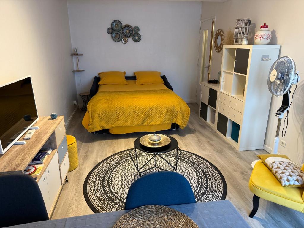 a bedroom with a bed and a table and chairs at Le studio du Faubourg in Nancy