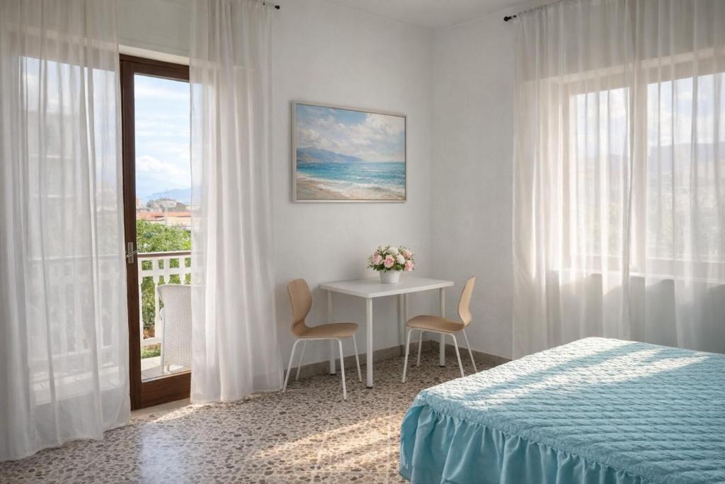 a bedroom with a table and a bed and a window at Sorrento life 3 in Sant'Agnello