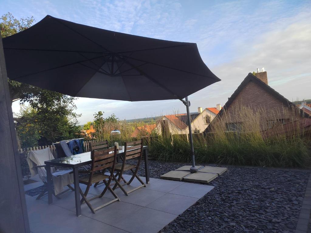 a table and chairs under an umbrella on a patio at Haus Auszeitblick in Bad Bentheim