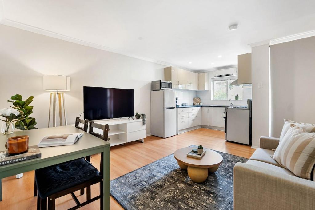 a living room with a couch and a table at Sunny Side Studio - Mosman Park in Mosman Park