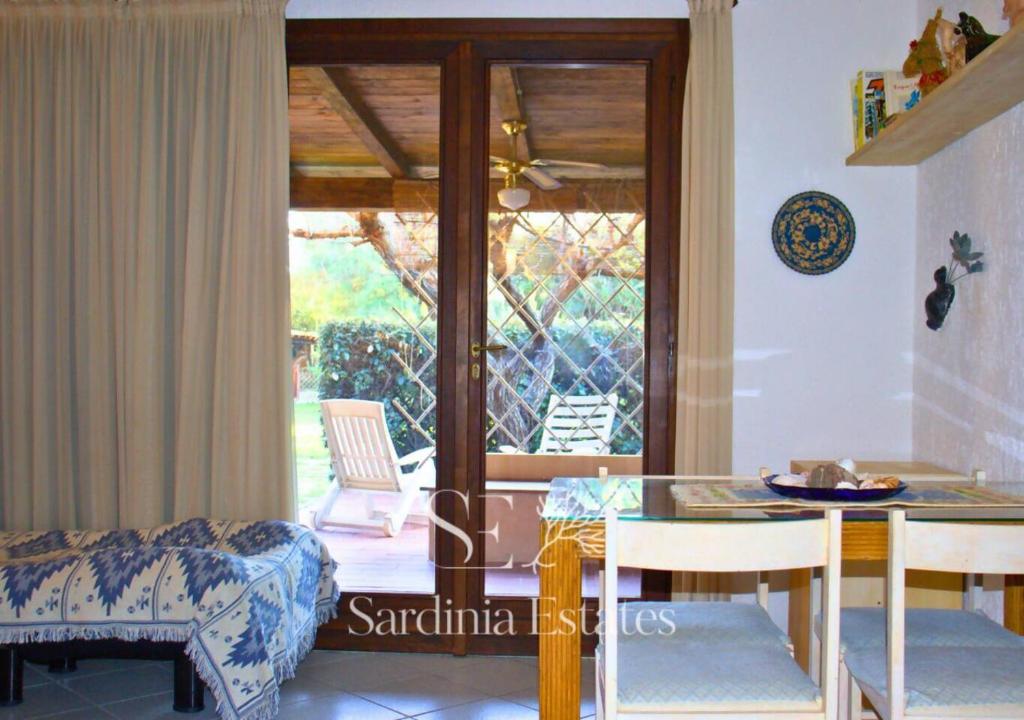 a living room with a table and chairs and a patio at Fronte spiaggia con parcheggio - Rainbow House in Porto Rotondo