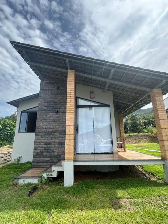 a house with a solar roof on top of it at Chalé Face de Cristo in Caparaó Velho