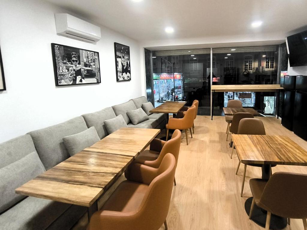 a dining room with wooden tables and chairs at Clérigos Cinema Guesthouse in Porto