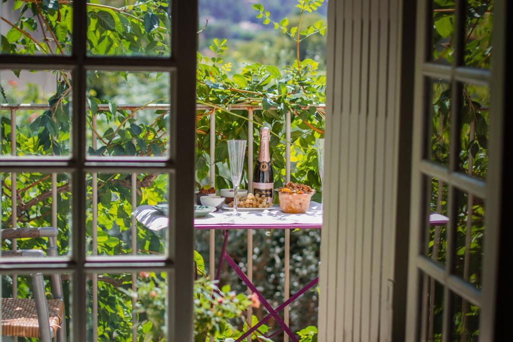 uma mesa num jardim vista através de uma janela em Ancienne Maison des Gardes em Lourmarin