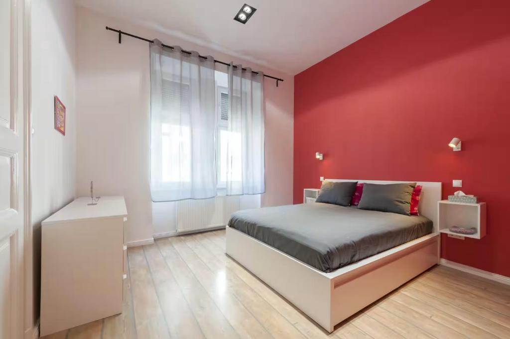 a red bedroom with a bed and a red wall at Apartments Paprikör in Tihany