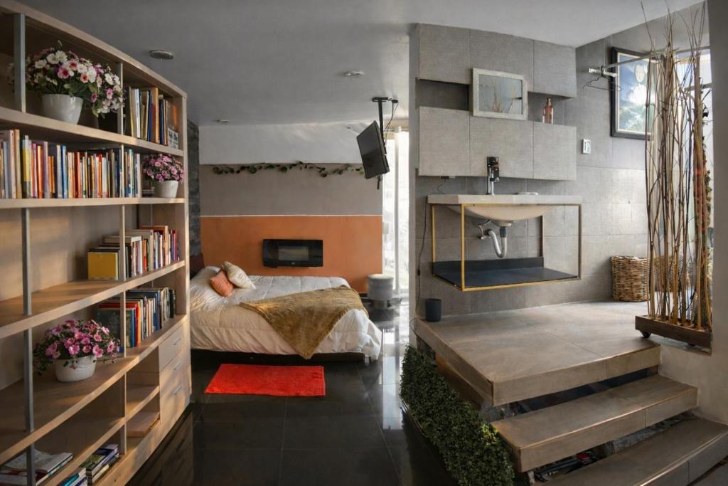 a bedroom with a bed and bookshelves at Amazing View From Los Fuertes in Puebla