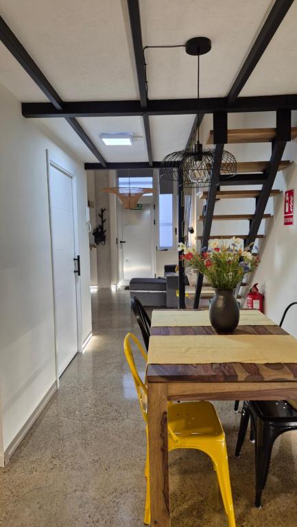 a dining room with a table and yellow chairs at A3 Valencia Ciudad cómodo Bajo Diseño hasta 6, wifi gratis in Valencia