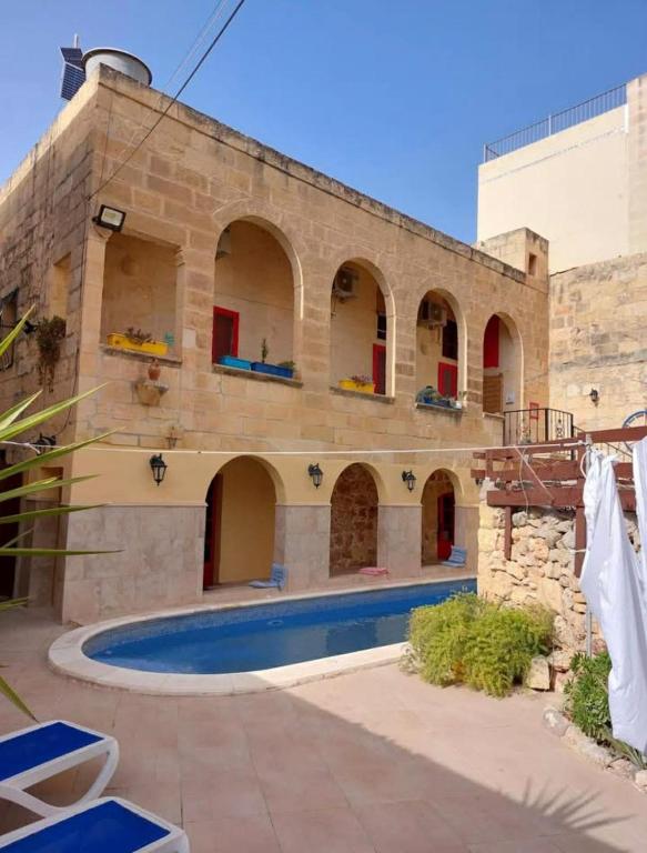 a building with a swimming pool in front of it at Dotties Retreat Qala in Qala