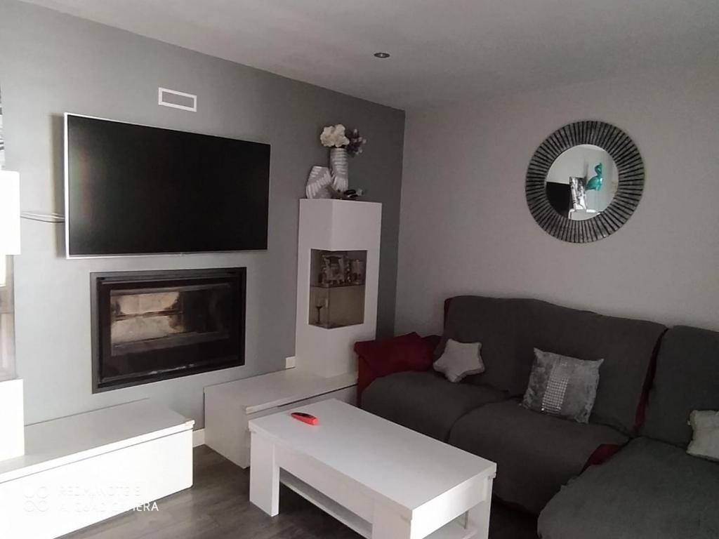 a living room with a couch and a flat screen tv at Alojamiento Patricia in Igualeja