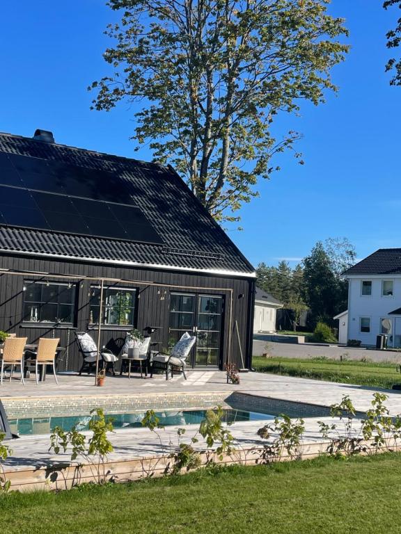 a house with a solar roof and a swimming pool at Villa Golfgatan 32 Vintrosa Lanna in Vintrosa